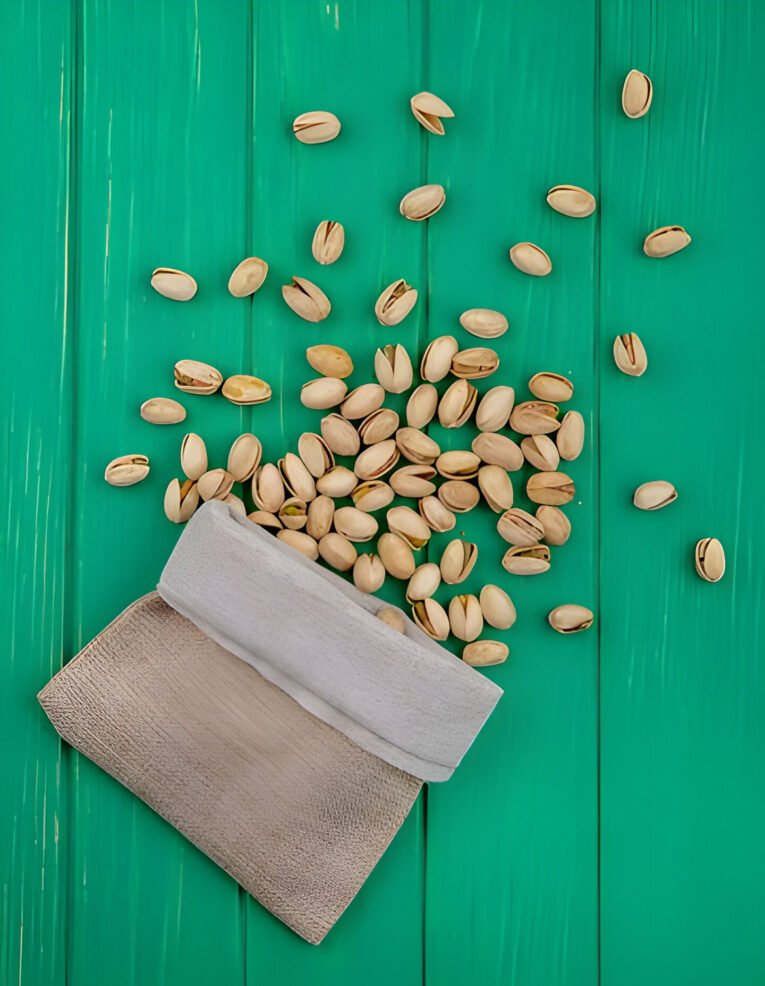 top-view-pistachios-burlap-bag-green-surface_141793-18422